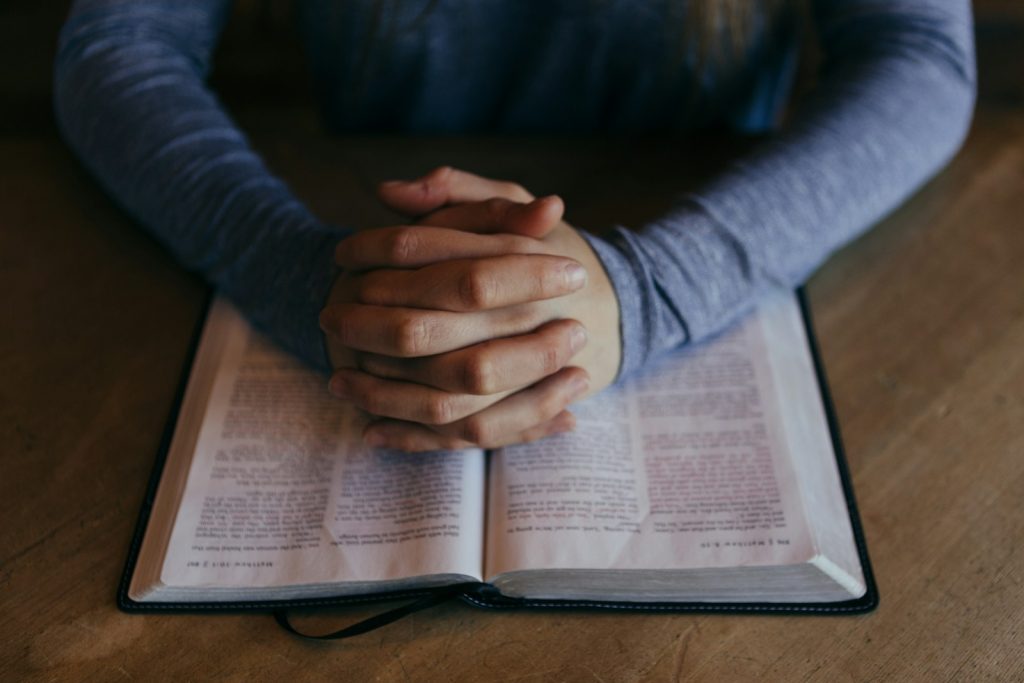 man holding his hands on open book